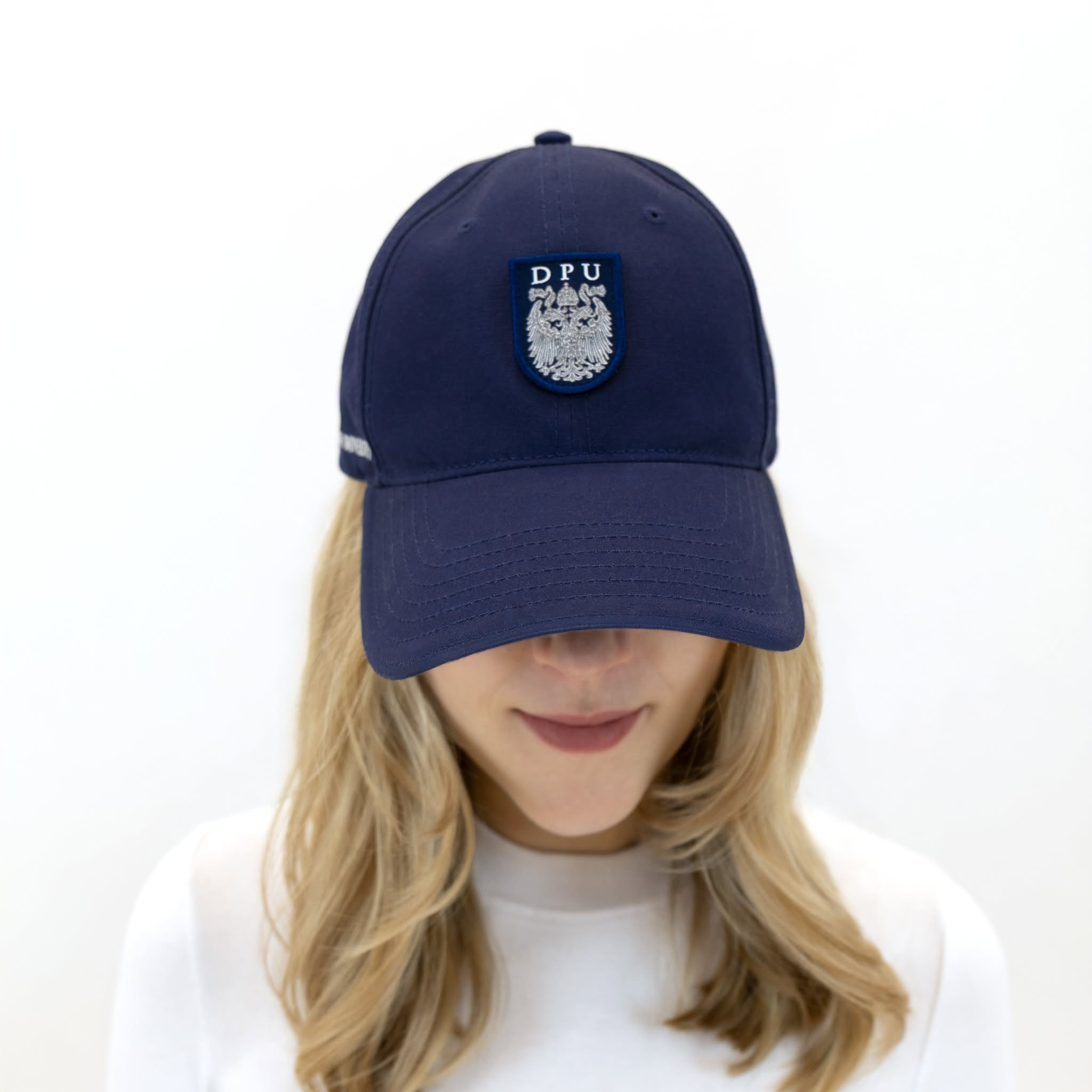 Blaue DPU-Baseballkappe mit tonfarbenem, aufgenähtem Wappen-Patch auf der Vorderseite und gesticktem DPU-Schriftzug an der rechten Kappenseite.