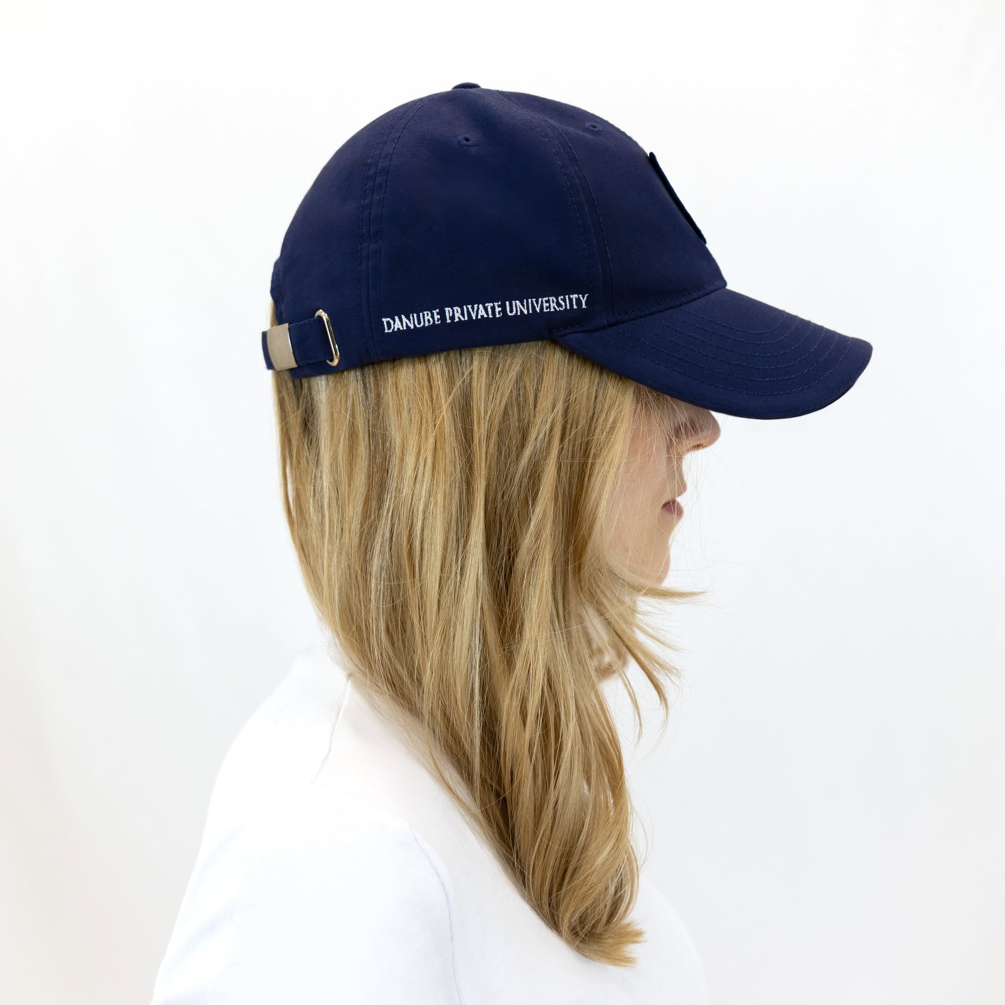 Blaue DPU-Baseballkappe mit tonfarbenem, aufgenähtem Wappen-Patch auf der Vorderseite und gesticktem DPU-Schriftzug an der rechten Kappenseite.