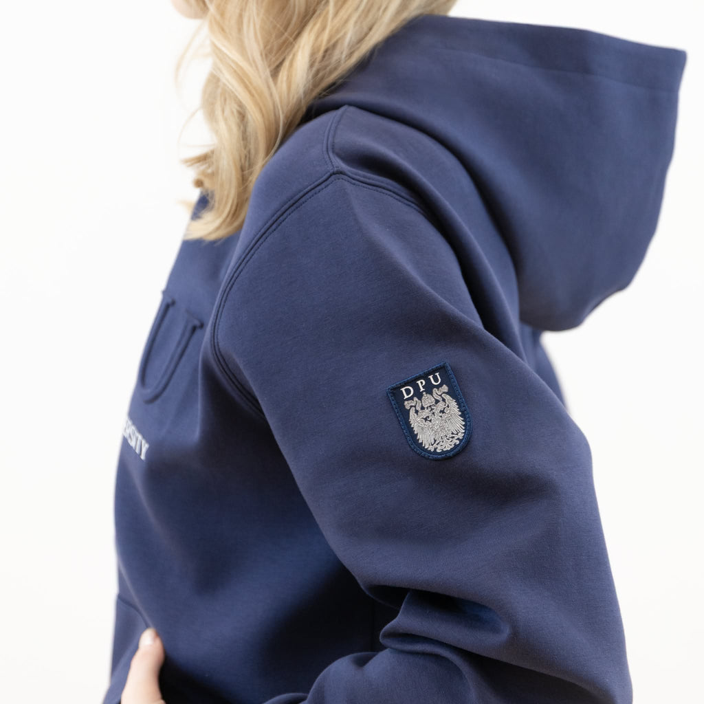 Blauer DPU-Hoodie mit geprägtem DPU-Logo, weißem Schriftzug auf der Vorderseite und aufgenähtem Wappen-Patch am linken Ärmel.